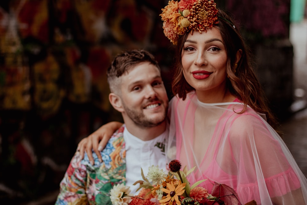 a man standing next to a woman in a pink dress