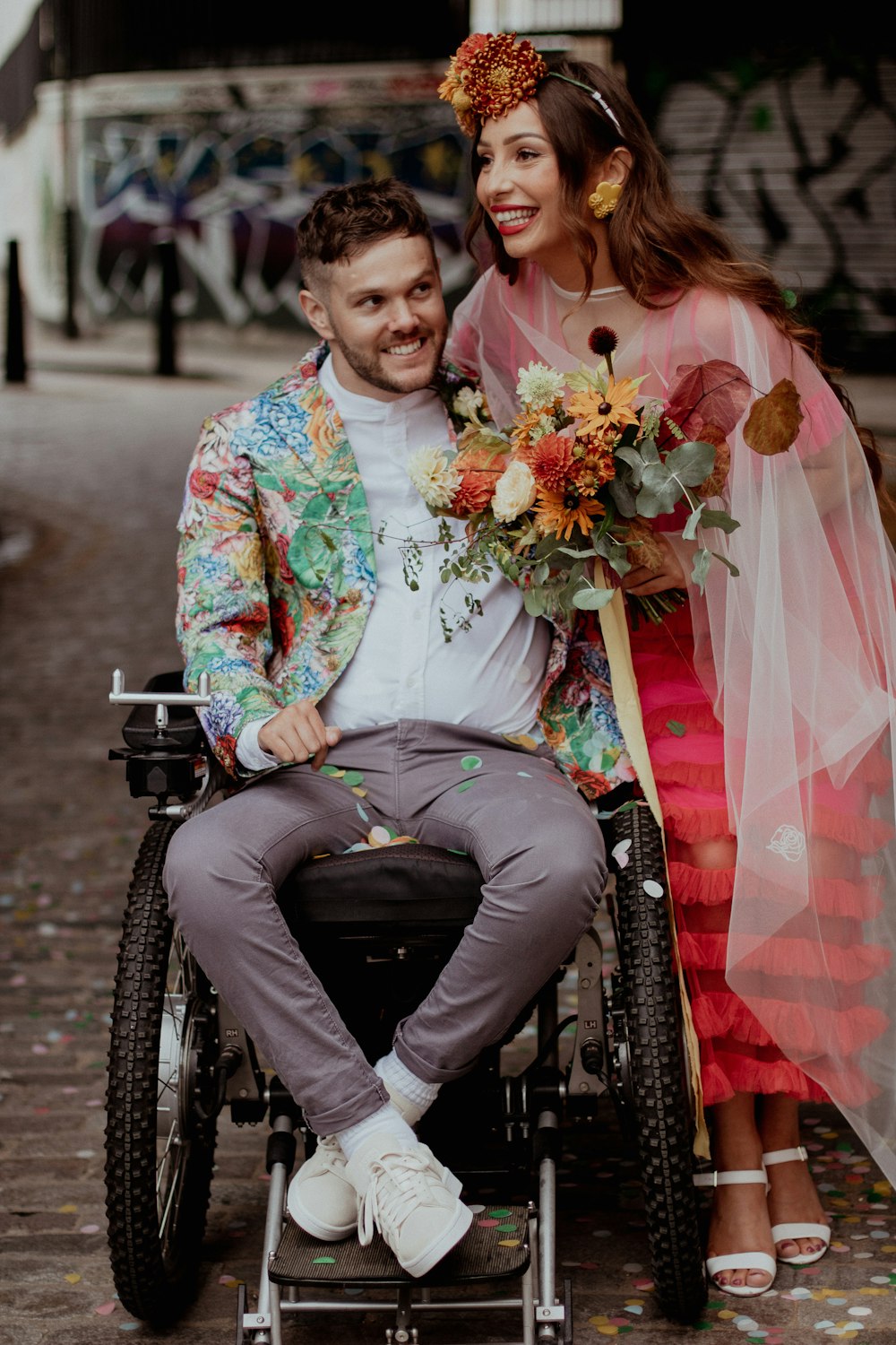 un hombre en silla de ruedas y una mujer con un vestido