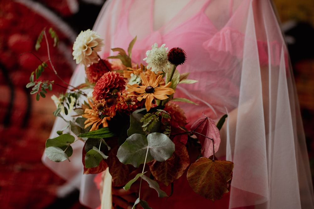 a woman in a pink dress holding a bouquet of flowers