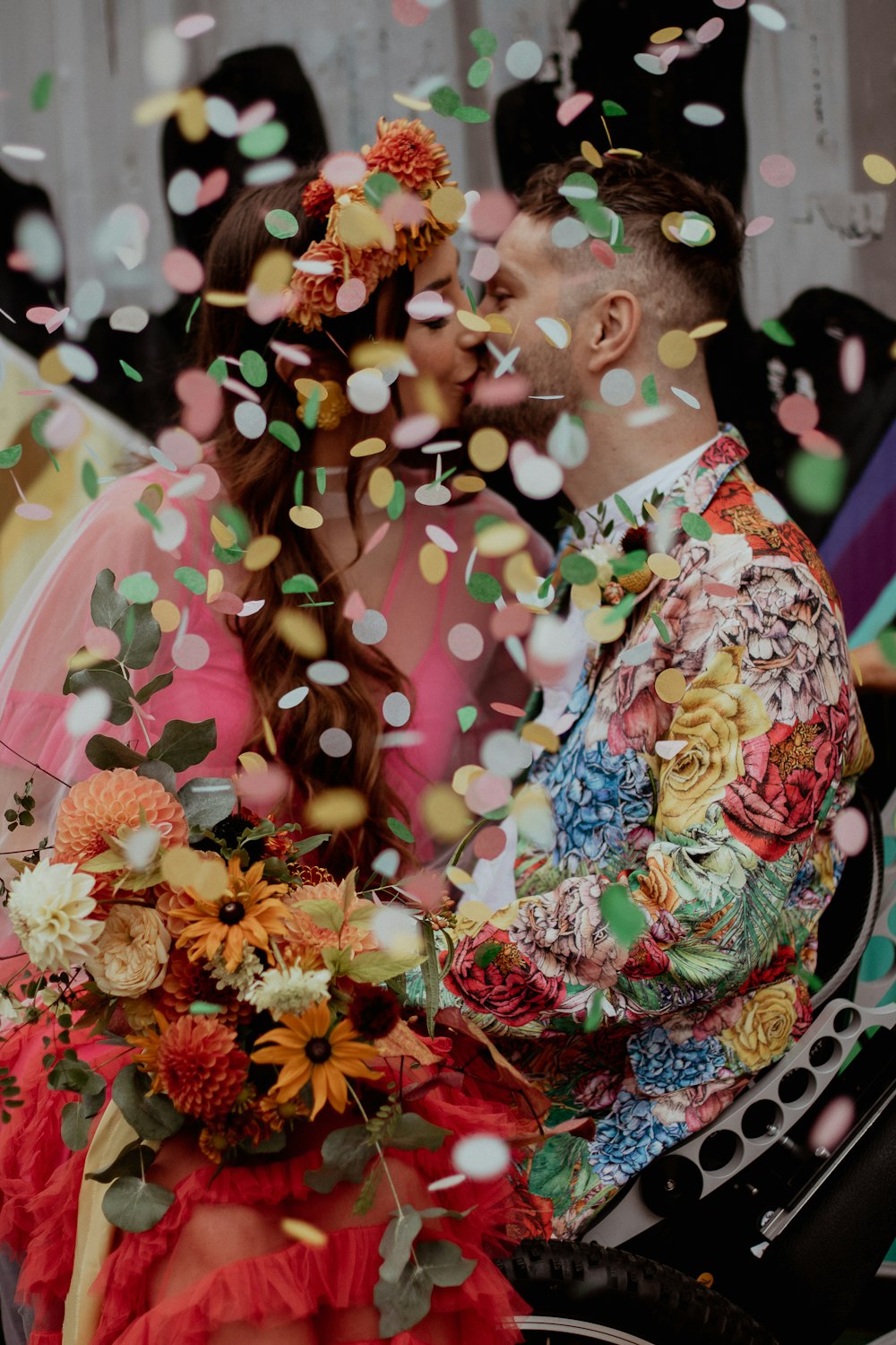 a man and a woman kissing under confetti