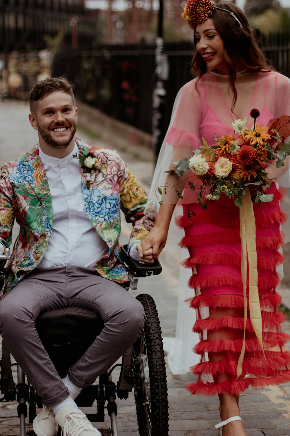Un hombre en silla de ruedas sosteniendo la mano de una mujer