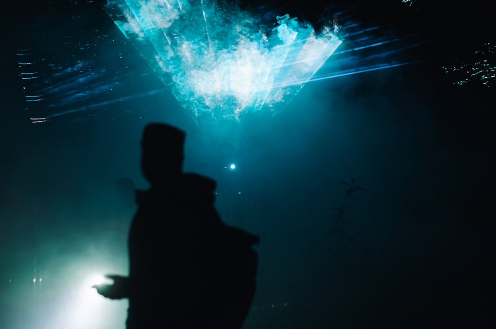 una silhouette di una persona in piedi di fronte a un palcoscenico