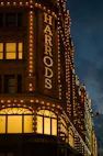 a building with a sign that says harrod lit up at night