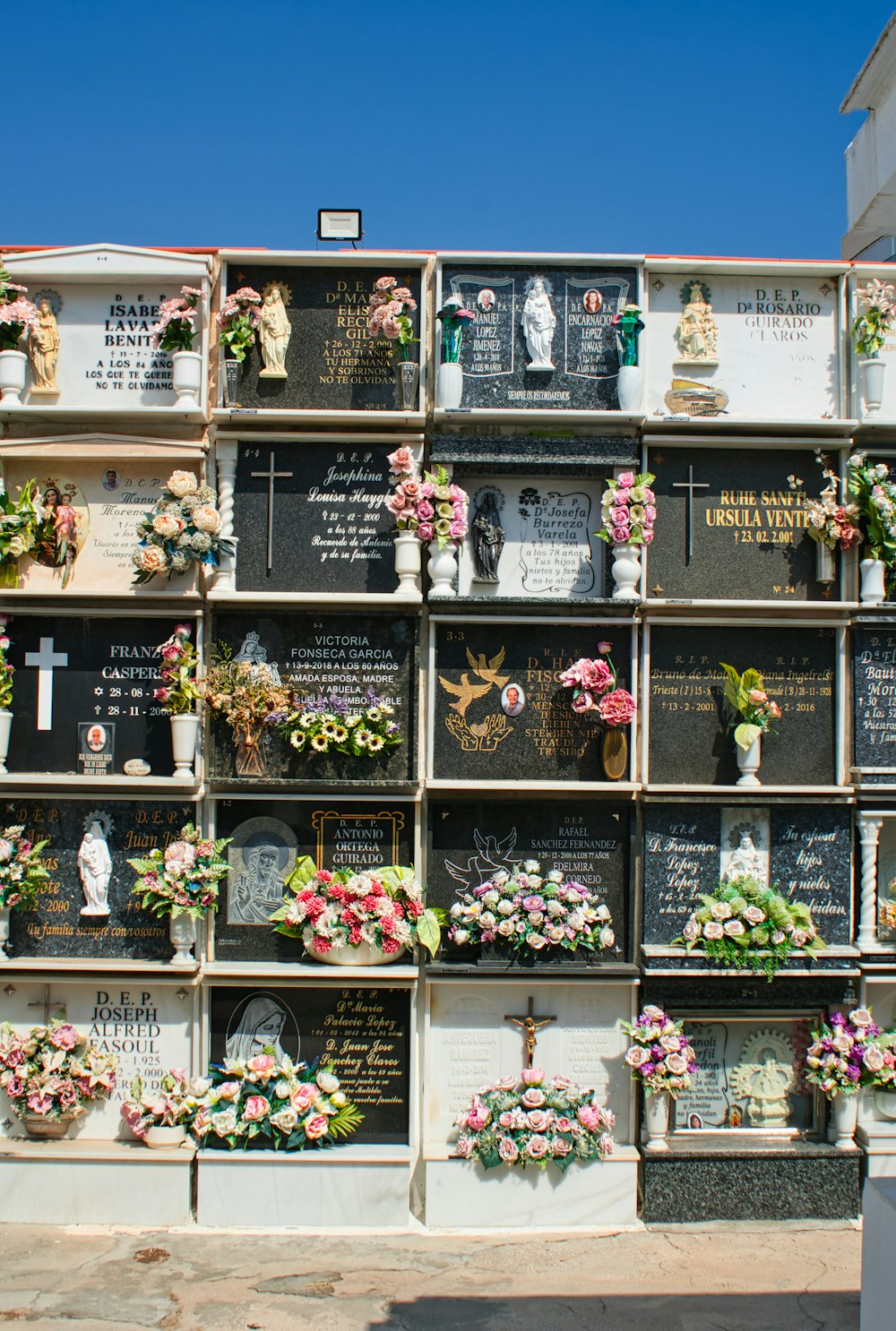 a memorial wall with flowers and plaques on it
