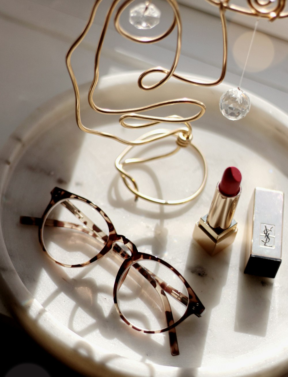 a pair of glasses and a lipstick on a plate