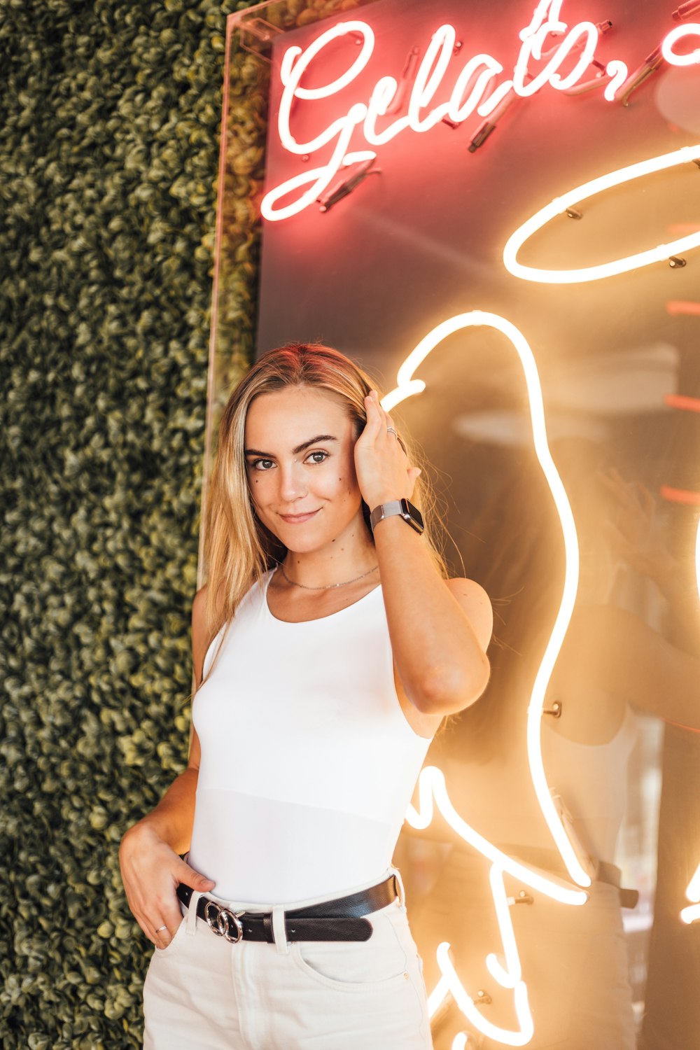 a woman standing in front of a neon sign