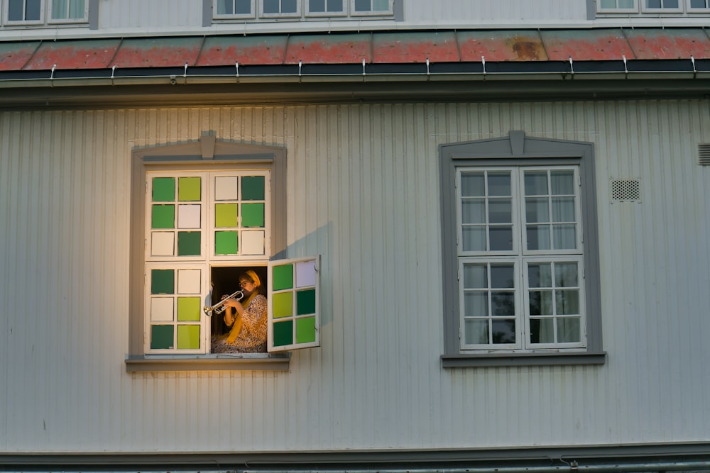 a woman is looking out of a window