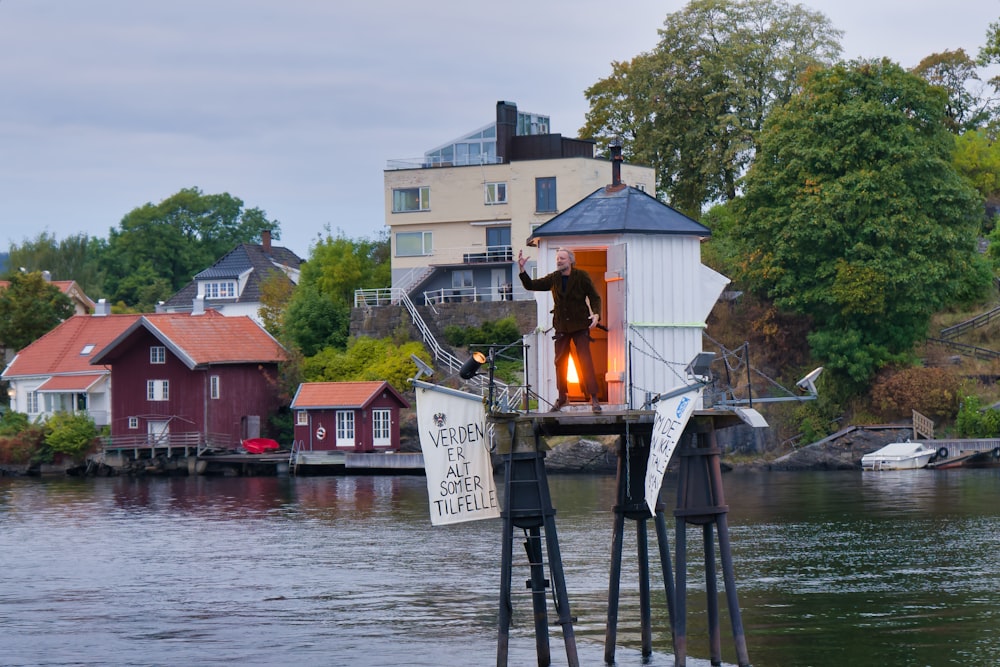 a man standing on a dock next to a body of water