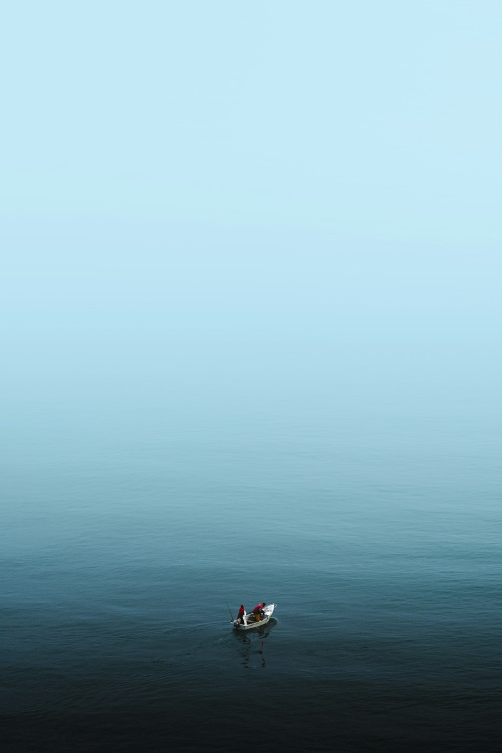 a small boat floating on top of a large body of water