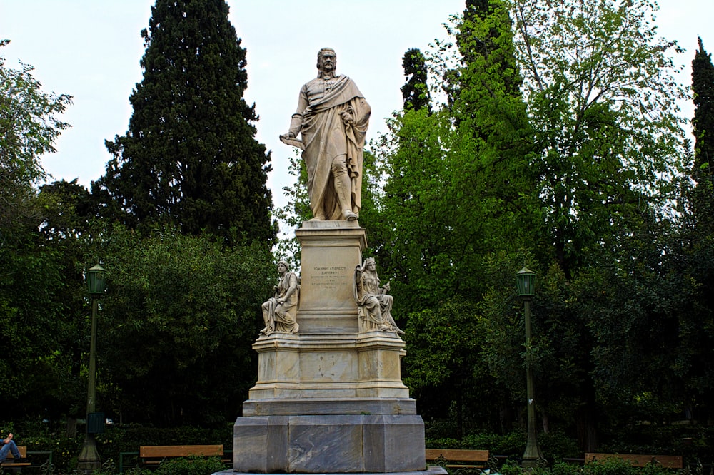 a statue of a man standing in a park