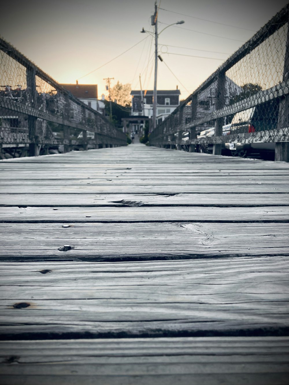 a wooden walkway with a fence in the background