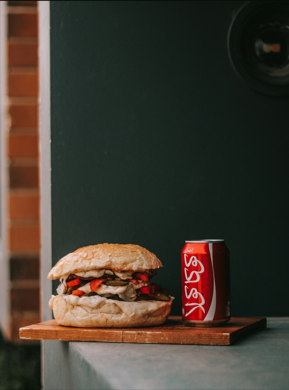 a sandwich and a can of soda on a table