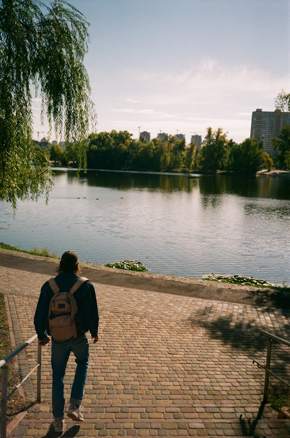 a person with a backpack walking up a brick path