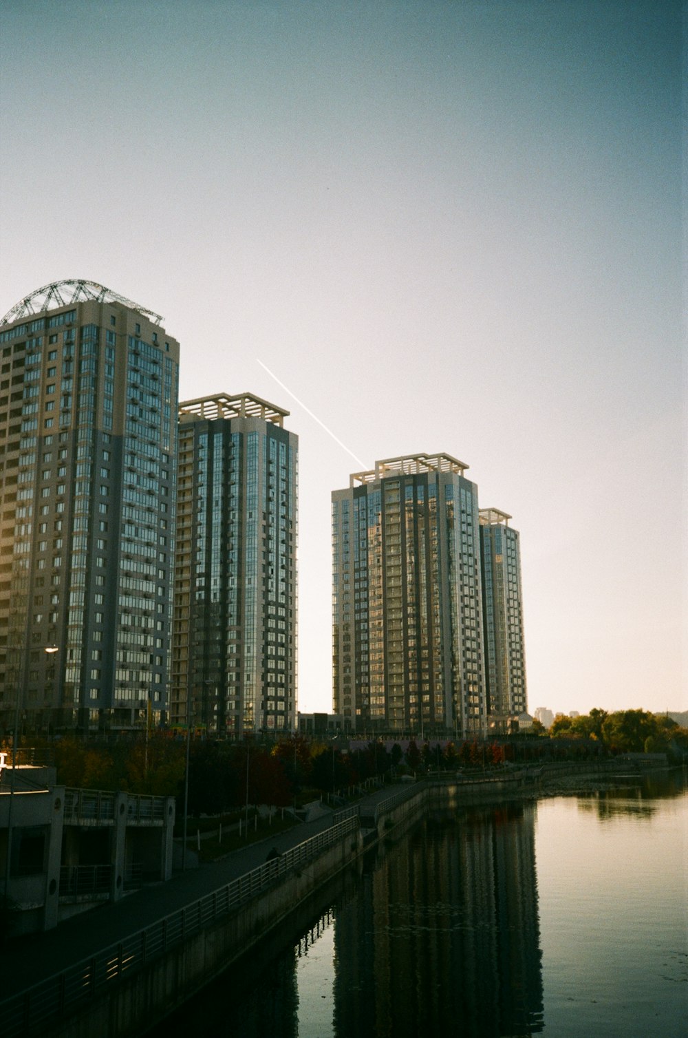 a couple of tall buildings sitting next to a body of water