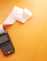 a cell phone sitting on top of a table next to a roll of paper