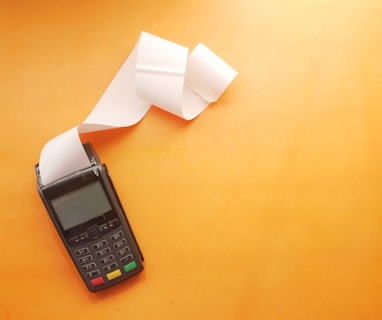 a cell phone sitting on top of a table next to a roll of paper