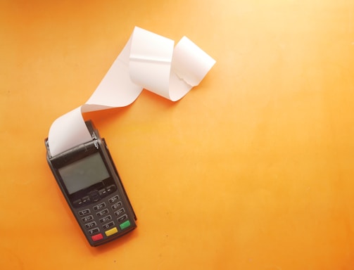 a cell phone sitting on top of a table next to a roll of paper