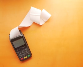 a cell phone sitting on top of a table next to a roll of paper