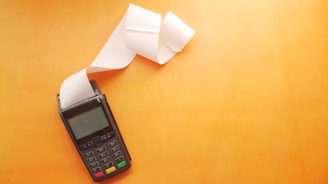 a cell phone sitting on top of a table next to a roll of paper