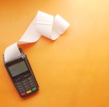 a cell phone sitting on top of a table next to a roll of paper