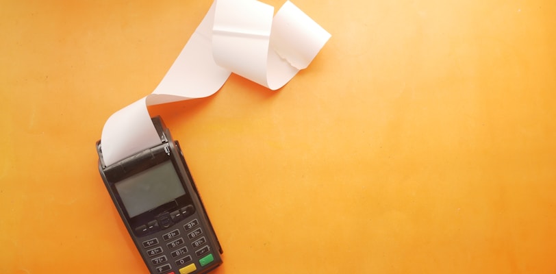 a cell phone sitting on top of a table next to a roll of paper