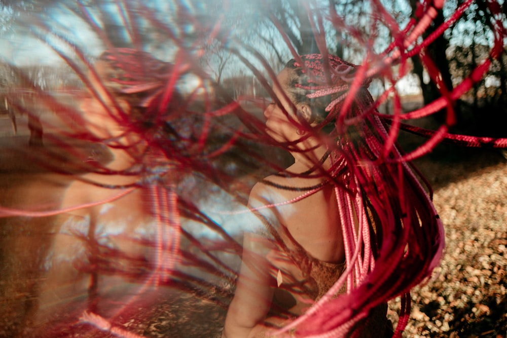 a woman in a red dress standing in a field