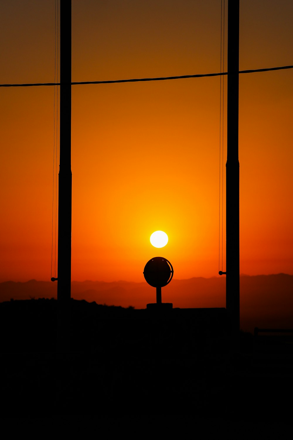 the sun is setting in the distance behind power lines