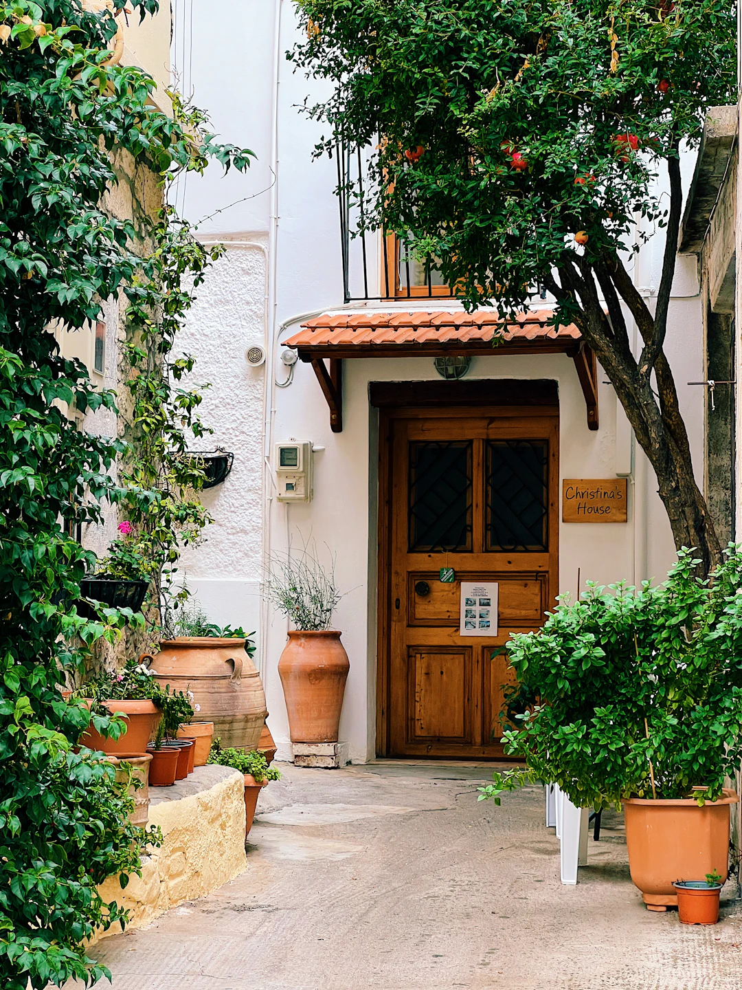 A doorway with potted plants in Kritsa