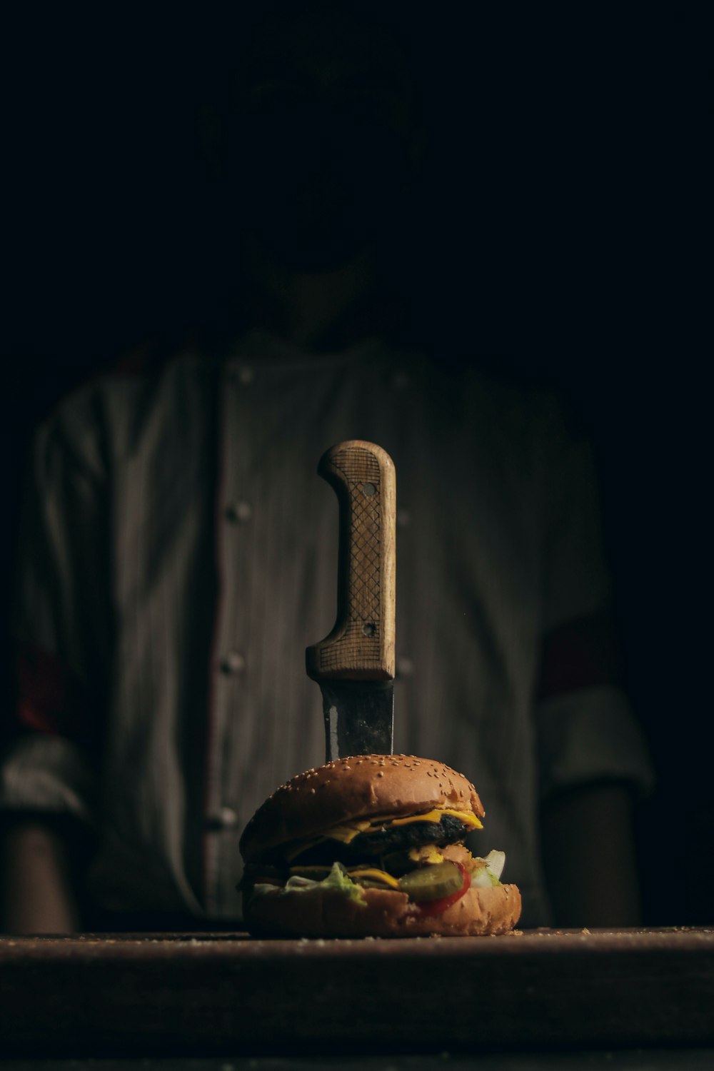 a hamburger with a knife sticking out of it