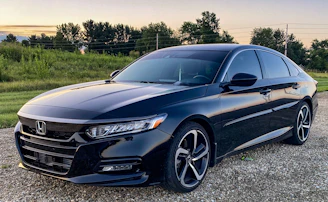 a black car parked on a gravel road
