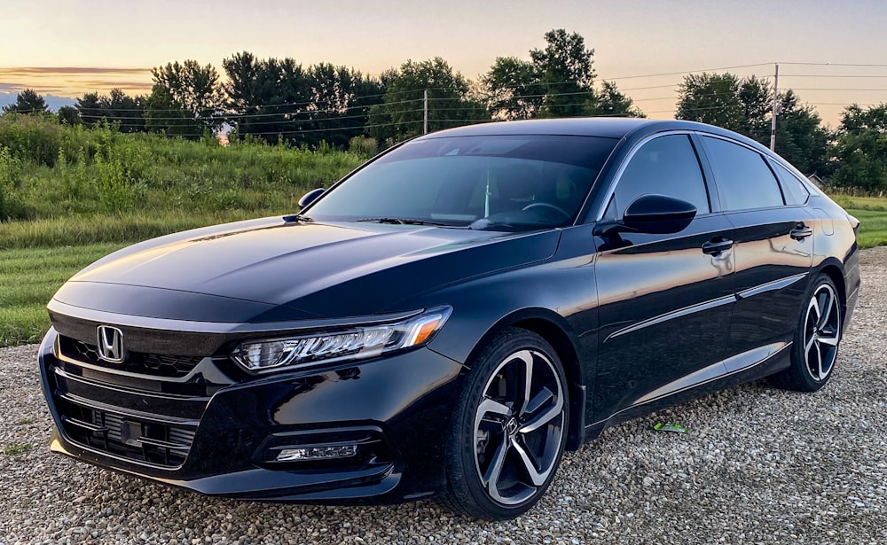 a black car parked on a gravel road