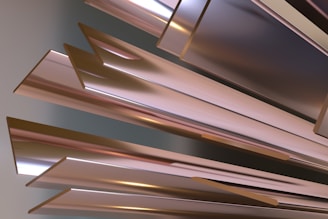 A collection of metallic, angular, and reflective surfaces arranged in a dynamic and abstract composition. The surfaces reflect subtle gradients of light and shadows, creating a sense of depth and movement.