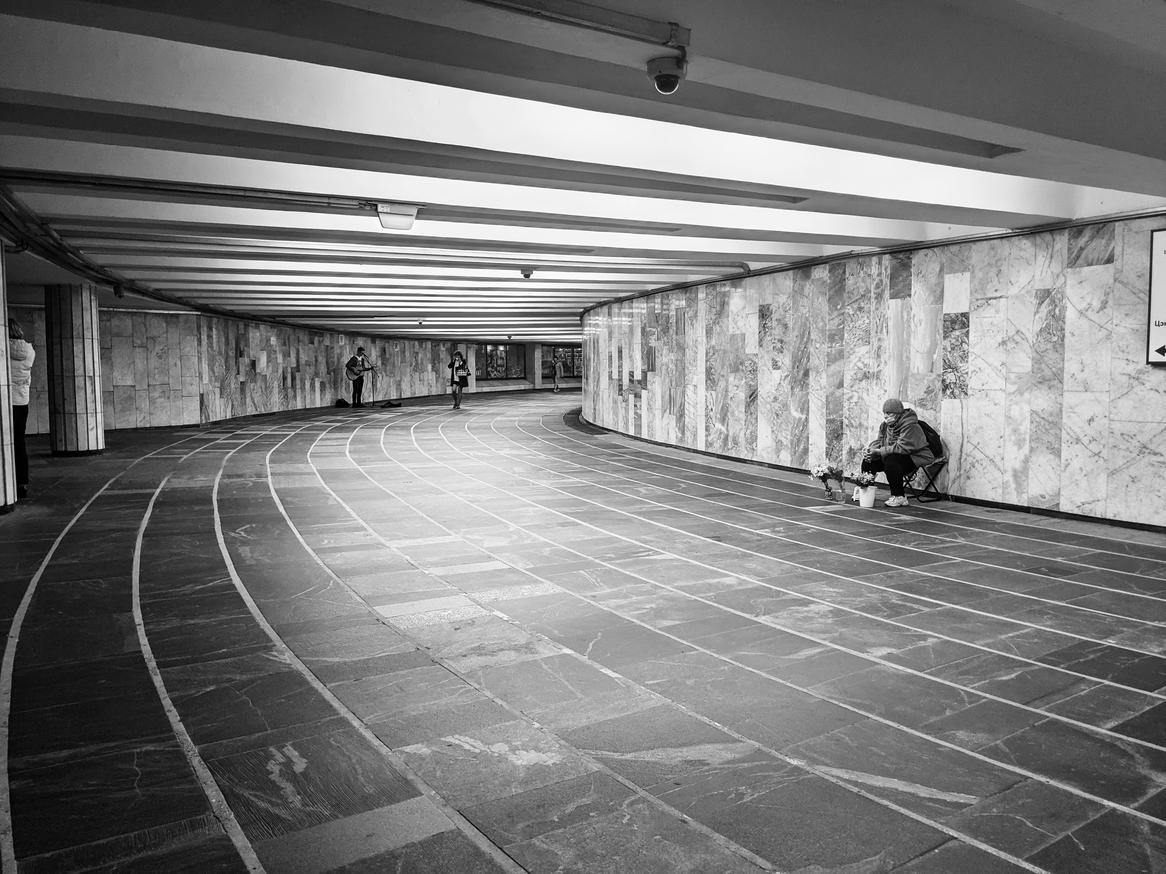 a black and white photo of a person sitting on a skateboard