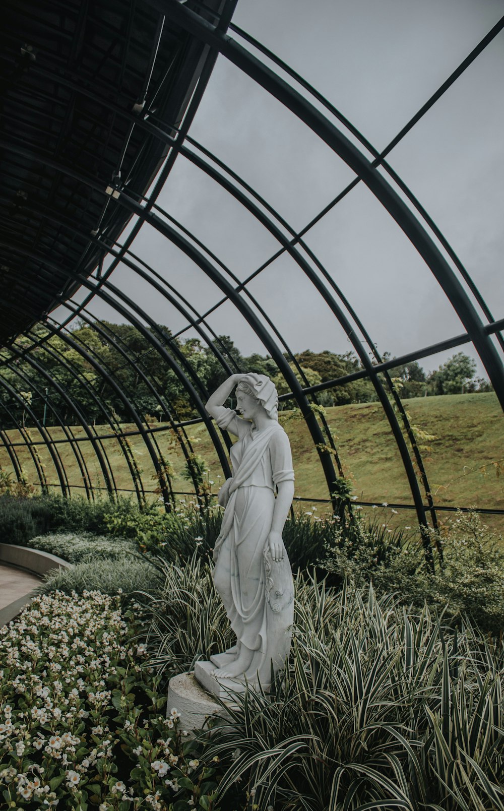 a statue of a woman standing in a garden