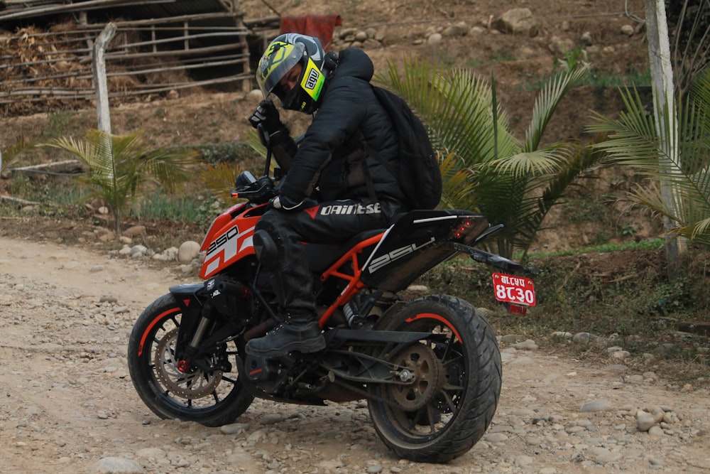 a man riding a motorcycle down a dirt road