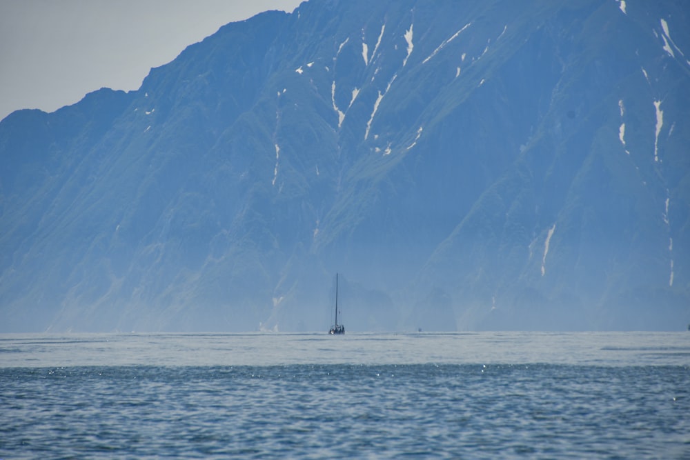 a boat in a body of water with a mountain in the background