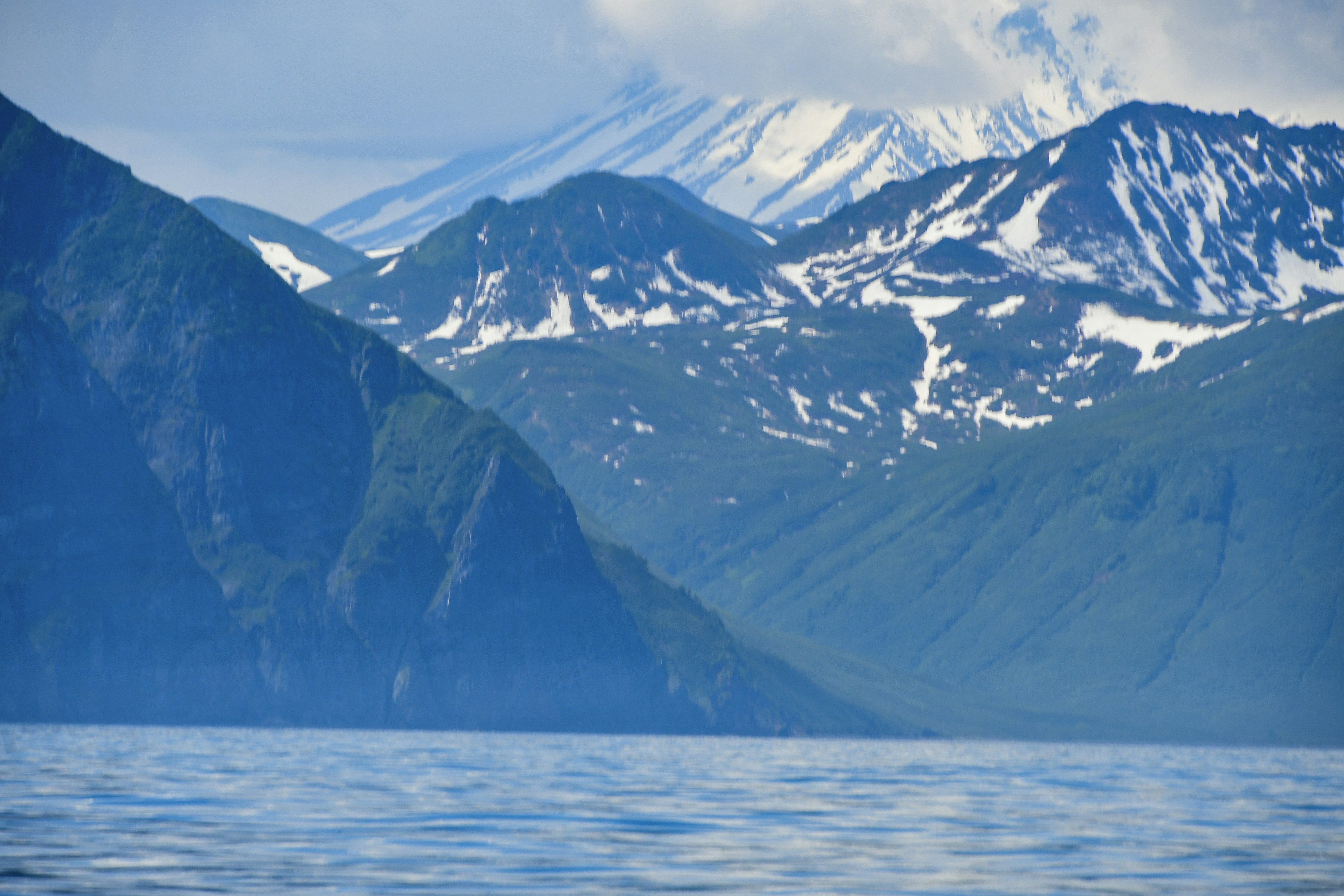 a large body of water with mountains in the background, 