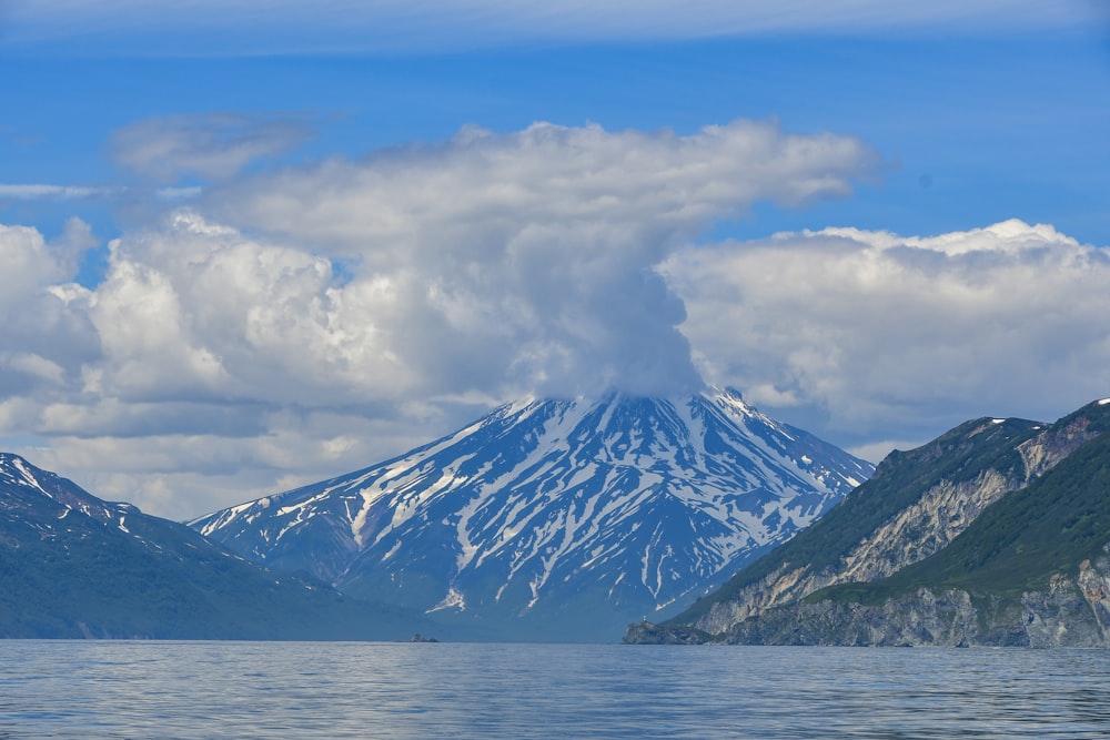 a snow covered mountain sitting above a lake