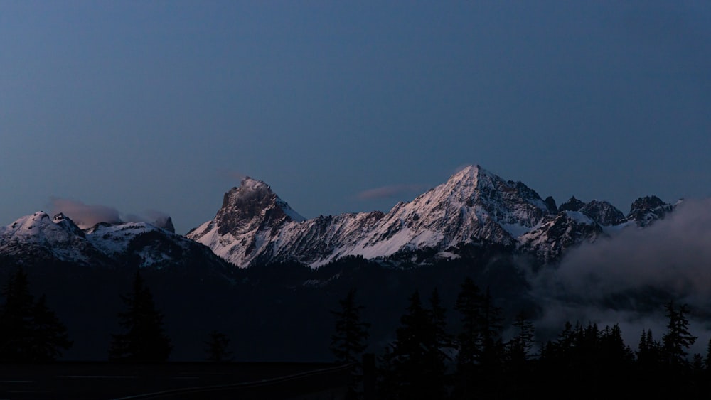 a view of a mountain range with trees in the foreground