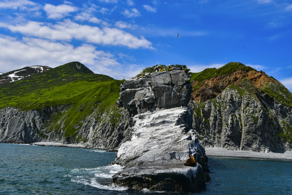 a large rock sticking out of a body of water