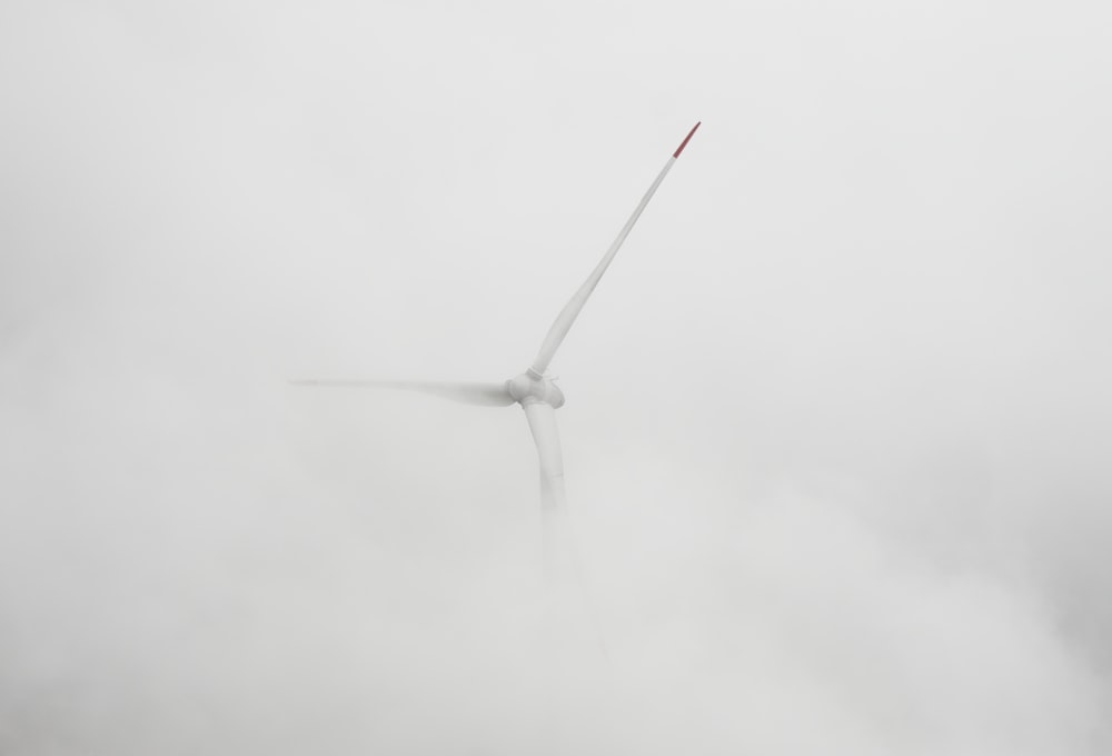 a wind turbine in the middle of a foggy day
