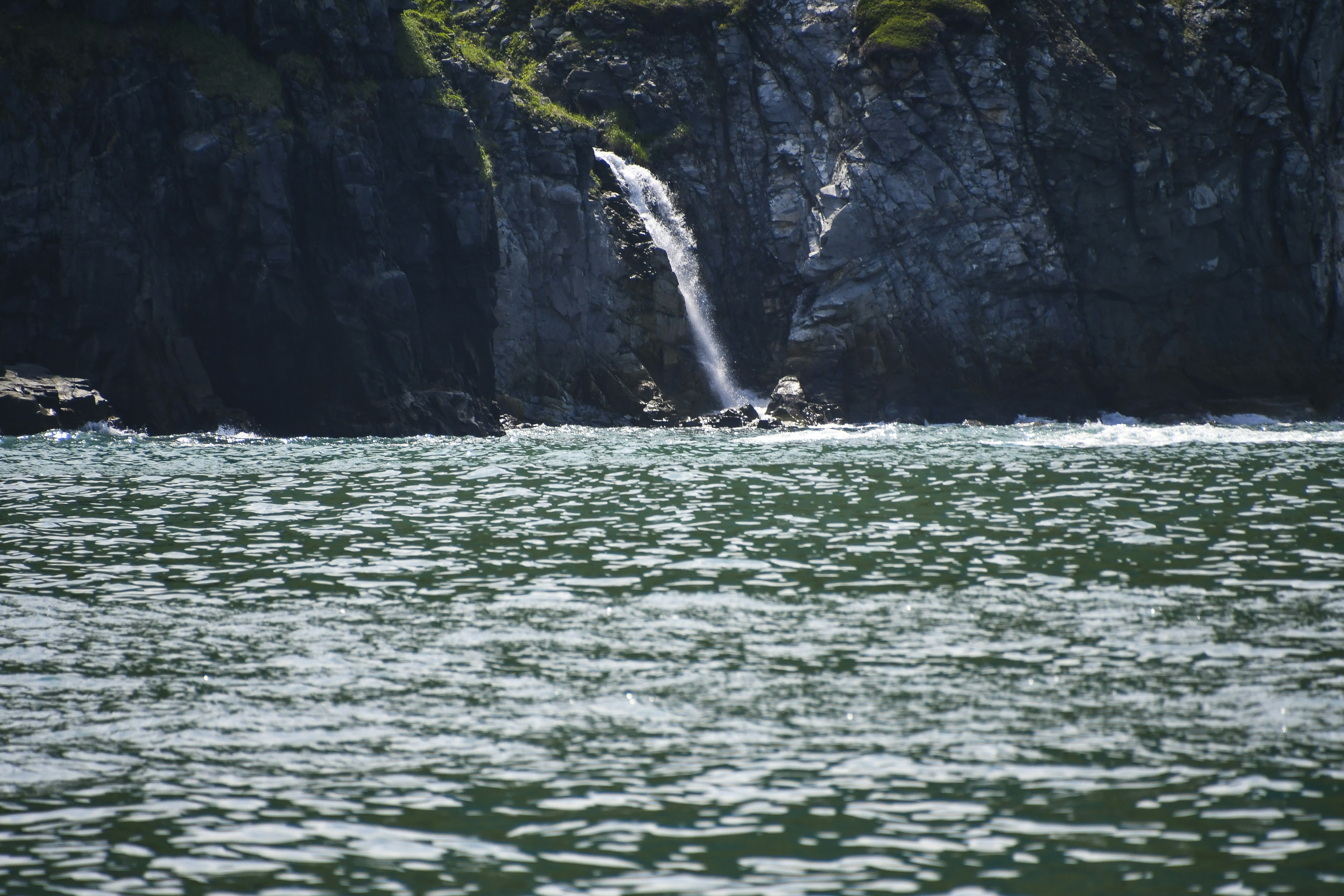 a waterfall is coming out of the side of a cliff