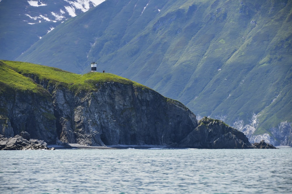 a lighthouse on top of a mountain overlooking a body of water