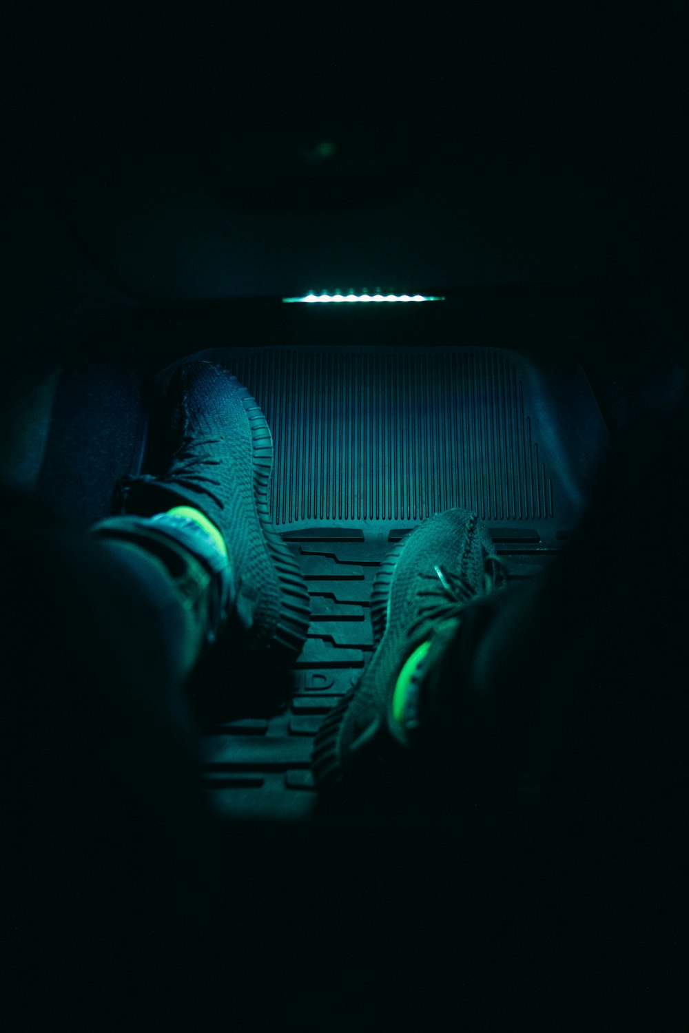 a person's feet in the dark in a car