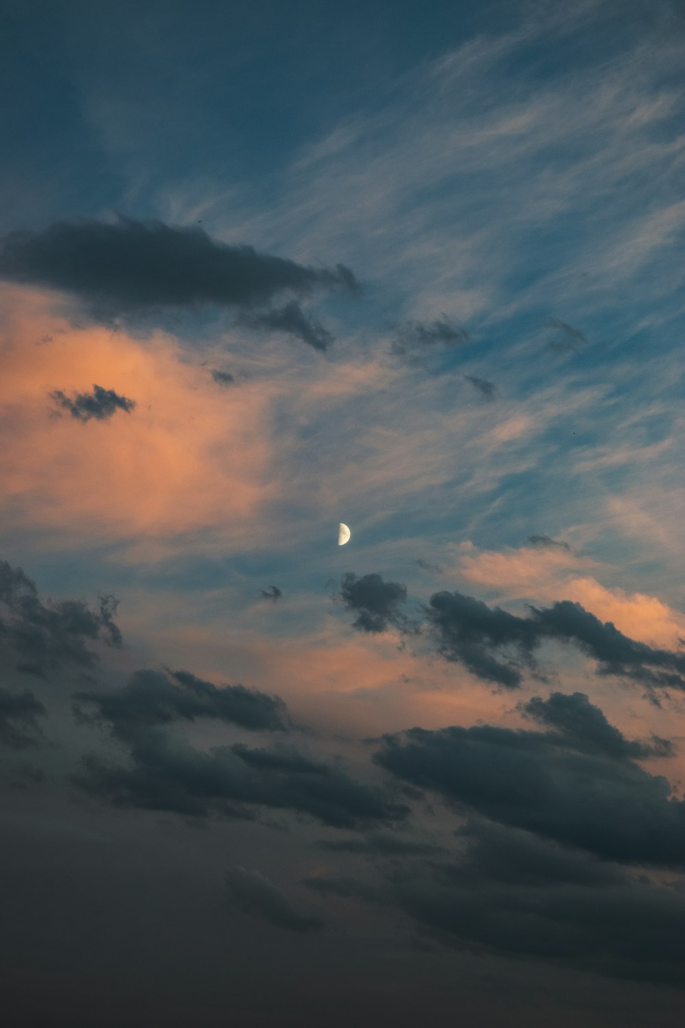 the moon is seen through the clouds in the sky