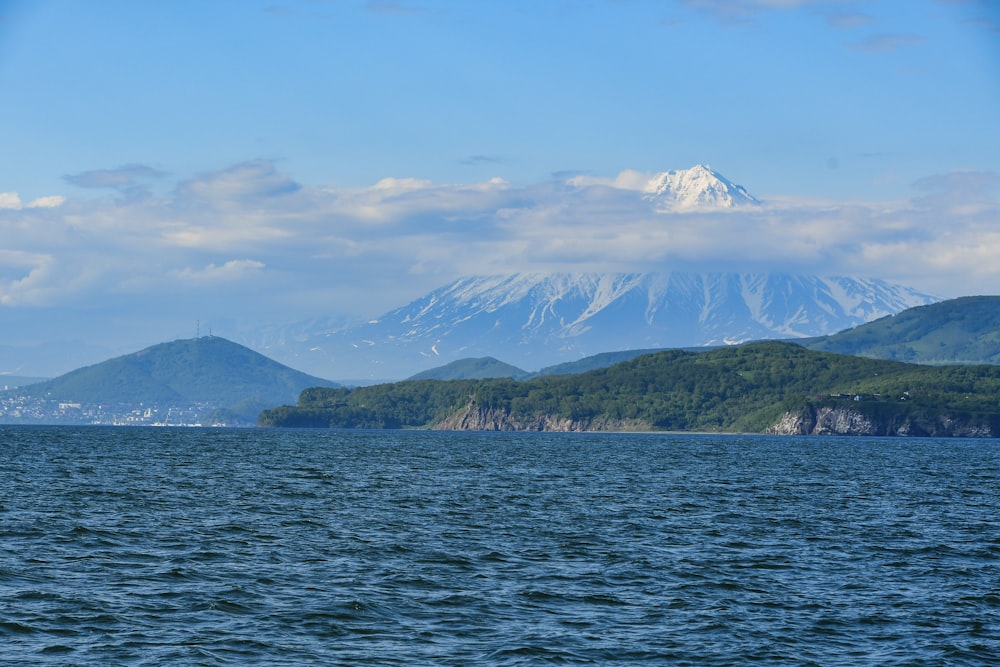 ein großes Gewässer mit Bergen im Hintergrund