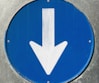 a close up of a blue sign with a white arrow