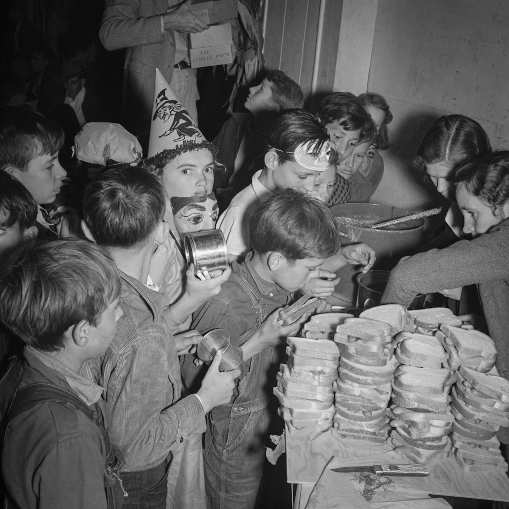Una foto in bianco e nero di un gruppo di bambini a una festa di compleanno