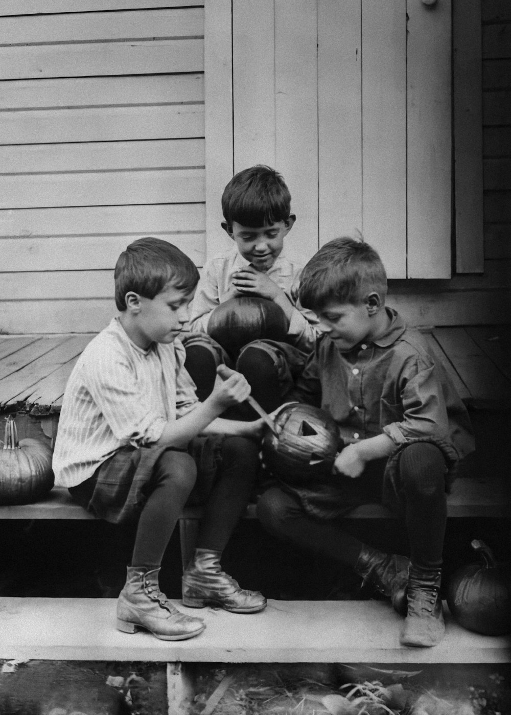 Eine Gruppe kleiner Jungen sitzt auf einer Holzbank
