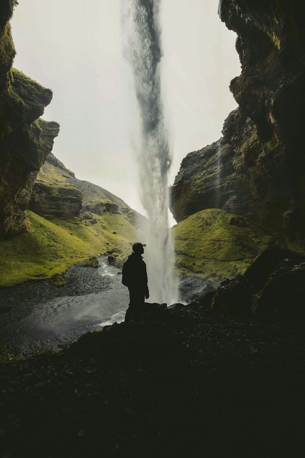 a man standing in front of a waterfall